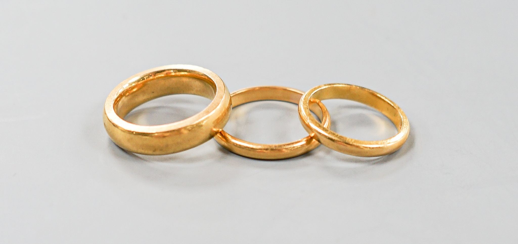 Two 22ct gold wedding bands, 7.1 grams and one other heavy yellow metal band, 12.1 grams.